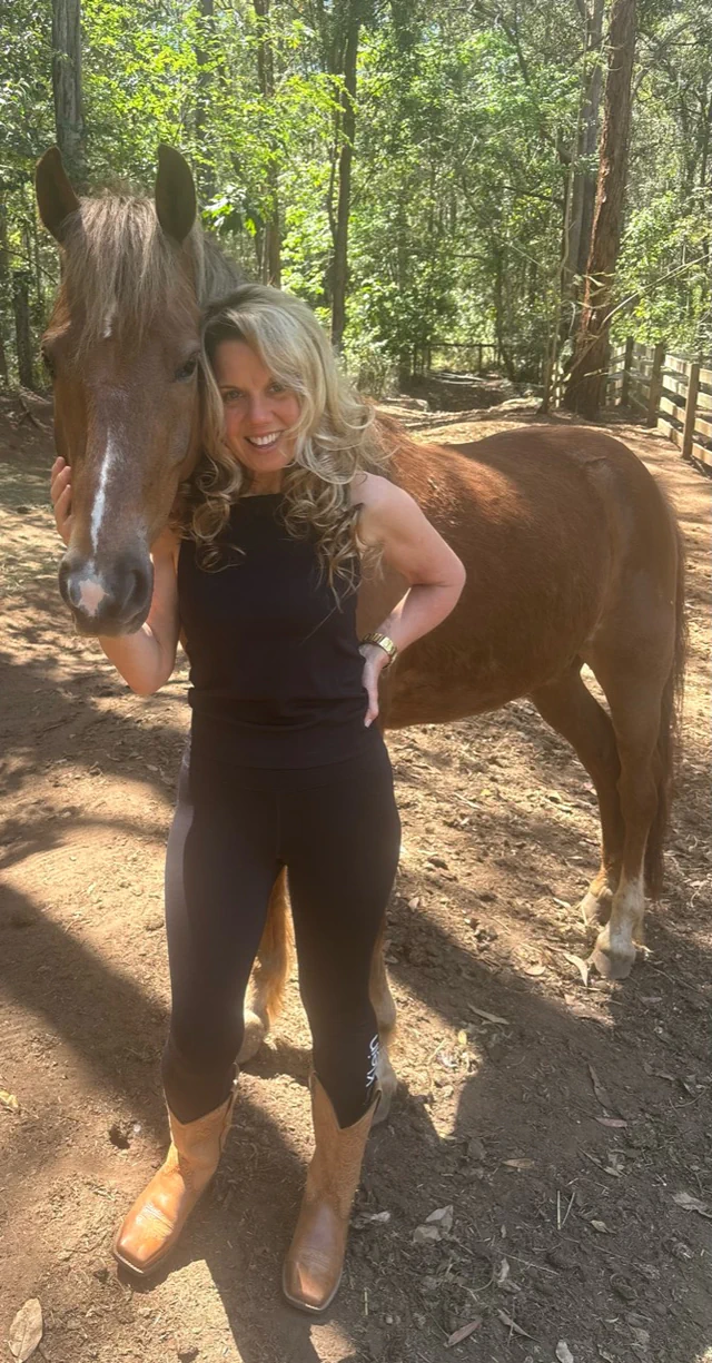 Jasmyn with Forrest, her brumby, outdoors among the trees